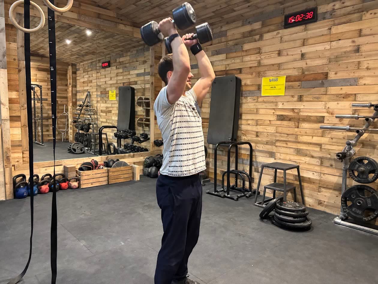 Someone doing an overhead press in the training area