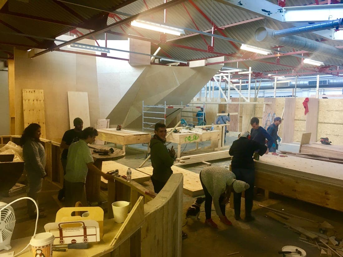 Volunteers working at benches in the unit, the first wall panels up behind them