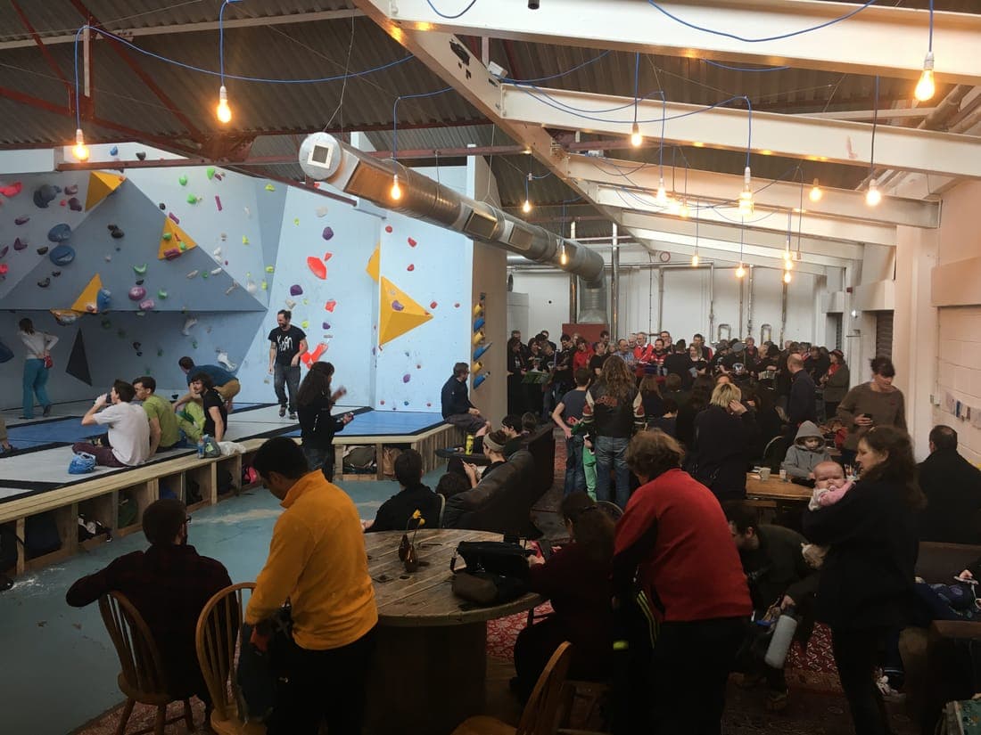 The café full of people on opening day, the finished walls behind them