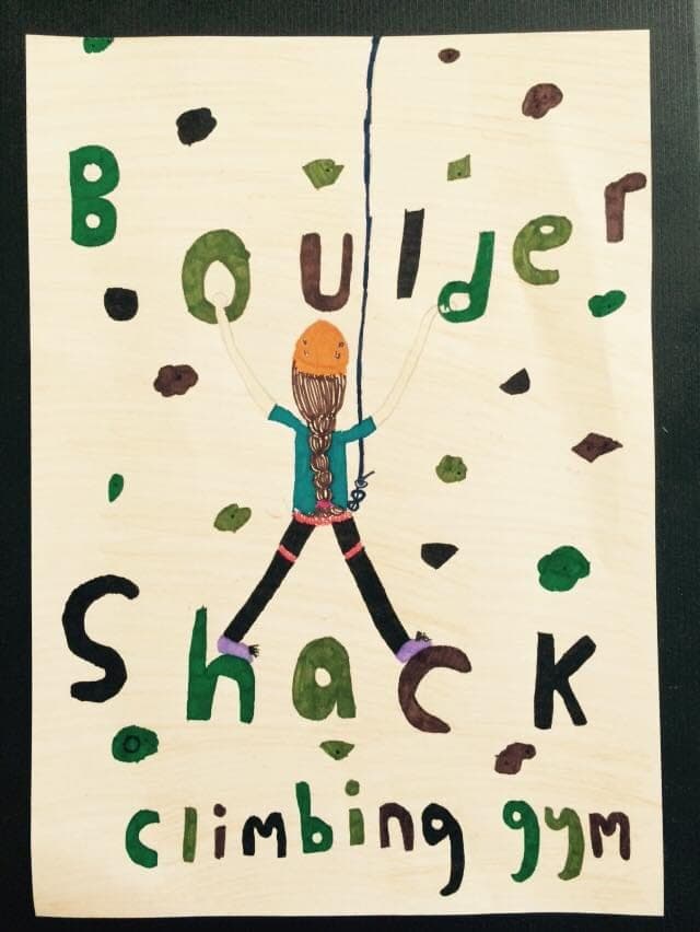 A child’s drawing of a climber in a helmet among coloured holds