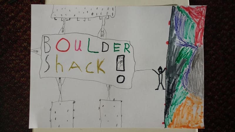 A child’s drawing of a climbing wall with a stick figure beside it