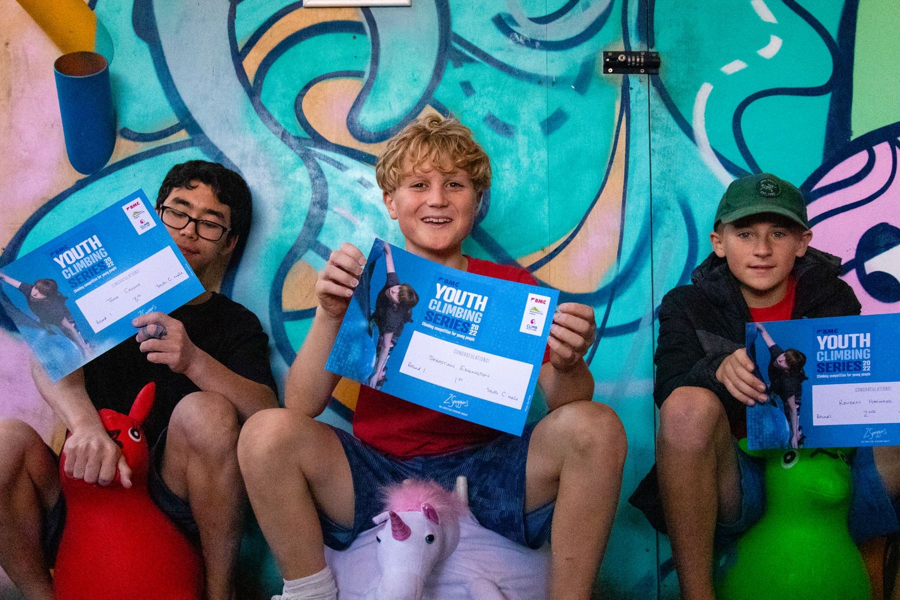 Three young climbers holding up their Youth Climbing Series certificates