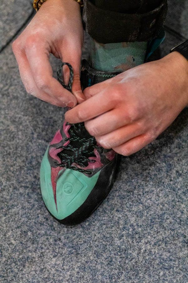 Somebody tying the laces of a hired climbing shoe