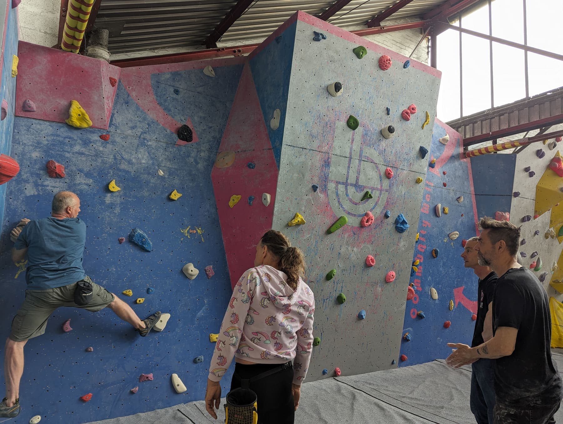 A climber on the wall with friends looking on