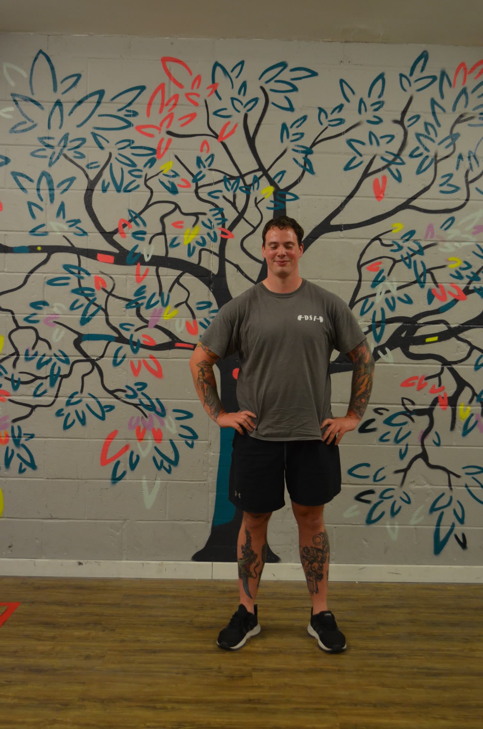 A member of the Boulder Shack team by the mural