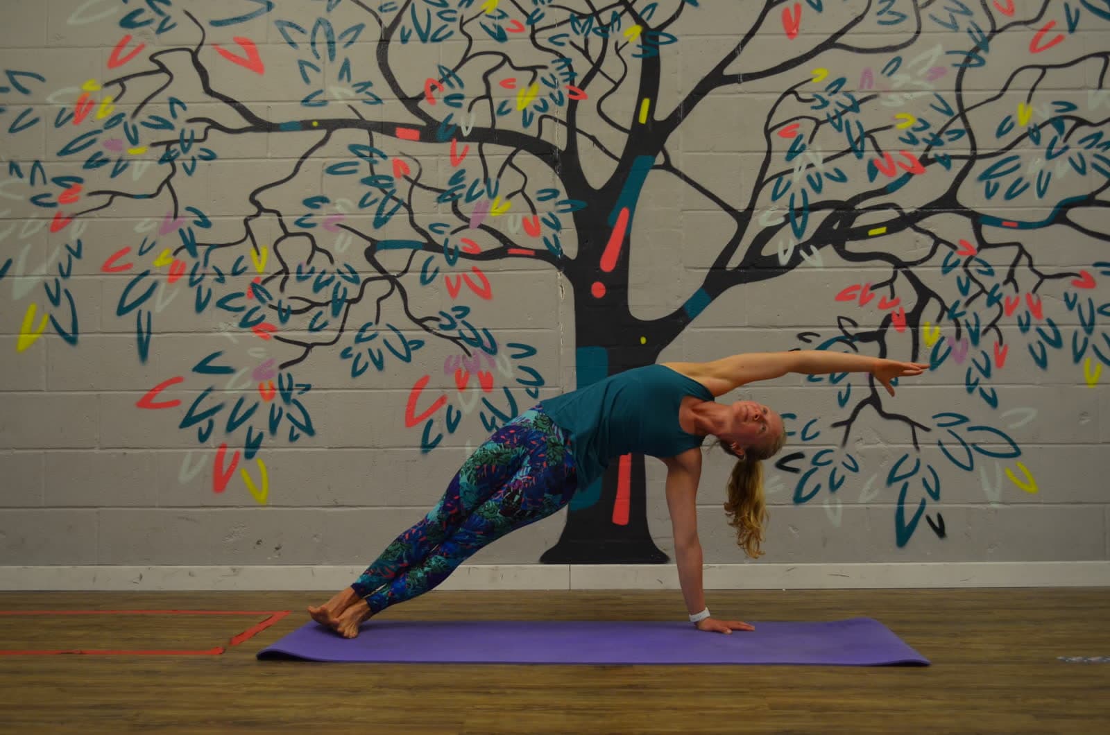A yoga side stretch on a mat in the studio